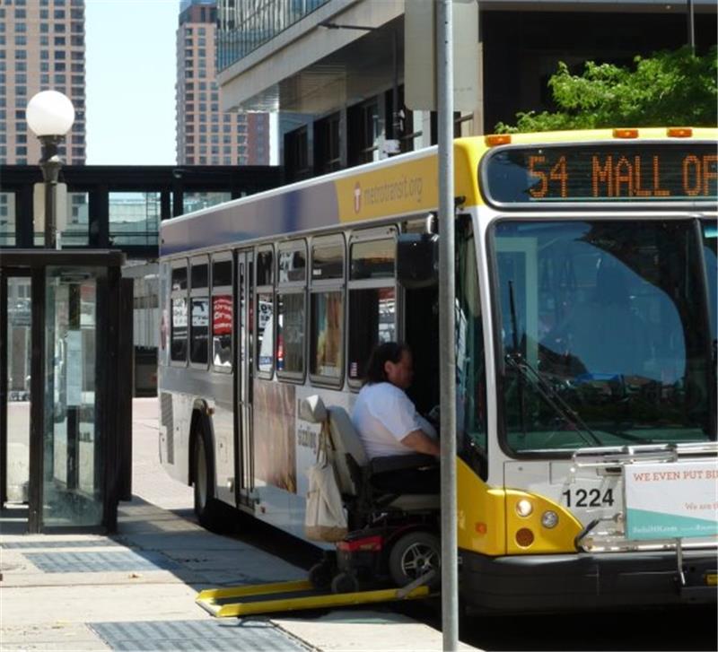A man in a wheel chair boards a Metro Transit bus